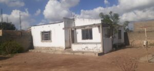 Por. Jornal Visão Moçambique Uma pequena casa branca em um campo de terra, com preço bonificado. Por. Jornal Visão Moçambique