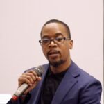 ARQUITETURA ELEITORAL EM MOÇAMBIQUE: HERMENEGILDO MULHOVO DEFENDE REFORMAS PROFUNDAS PARA REDUZIR PARTIDARIZAÇÃO E REFORÇAR CONFIANÇA PÚBLICA MAPUTO – O especialista e actor cívico Hermenegildo Mulhovo defende uma reestruturação profunda da arquitectura institucional eleitoral em Moçambique, alertando que o actual modelo permanece fortemente condicionado por dinâmicas partidárias que fragilizam a confiança pública e a independência das instituições de gestão eleitoral. A posição surge no âmbito de uma análise intitulada "Arquitetura Institucional e Administração Eleitoral em Moçambique: Uma Leitura Contextual das Reformas e dos Desafios da Justiça Eleitoral", onde o autor revisita três décadas de democracia multipartidária e os seus impactos na configuração da Comissão Nacional de Eleições (CNE) e do Secretariado Técnico de Administração Eleitoral (STAE). O estudo sustenta que a consolidação da democracia moçambicana depende de uma arquitectura eleitoral mais técnica, menos politizada e capaz de garantir equilíbrio entre eficiência administrativa e independência institucional. CONTEXTO HISTÓRICO E ENQUADRAMENTO DAS REFORMAS Na sua análise, Hermenegildo Mulhovo sublinha que o desenho actual das instituições eleitorais não pode ser compreendido fora do contexto dos processos de paz e dos ciclos eleitorais marcados por tensões políticas recorrentes. Segundo o autor, as reformas eleitorais resultam, em grande medida, de negociações entre actores políticos com interesses divergentes, o que influencia directamente a estrutura e funcionamento dos órgãos eleitorais. “As regras do jogo eleitoral são definidas em contextos marcados por interesses políticos, relações de poder e percepções de risco por parte dos actores envolvidos”, afirma Mulhovo no seu estudo. O especialista destaca ainda que reformas estruturantes, como as registadas em 2014, emergiram de momentos de elevada tensão política entre o Governo e a oposição, evidenciando a natureza negociada e não puramente técnica da evolução institucional. PARTIDARIZAÇÃO E CRISE DE CONFIANÇA INSTITUCIONAL Um dos eixos centrais do estudo é a crítica ao que Hermenegildo Mulhovo denomina de “partidocracia”, conceito usado para descrever a influência directa e estrutural dos partidos políticos na administração eleitoral. Segundo o autor, a actual composição da CNE, que integra representantes partidários e da sociedade civil, resultou da tentativa de construir confiança num ambiente histórico de desconfiança política. No entanto, este modelo acabou por gerar novas fragilidades institucionais. Mulhovo observa que, em determinados momentos, as reformas tiveram também motivações de natureza política e organizacional. “Havia igualmente uma preocupação de natureza organizacional e política: a necessidade de acomodar quadros partidários que haviam perdido posições nos níveis municipais”, refere o estudo. O investigador alerta ainda que a sociedade civil, embora formalmente representada, acaba muitas vezes por ser influenciada pelos próprios partidos políticos, o que compromete a sua independência e função de mediação institucional. “Os representantes da sociedade civil acabam frequentemente por ser indicados ou apoiados pelos próprios partidos políticos”, lê-se na análise. PROPOSTAS PARA PROFISSIONALIZAÇÃO DO SISTEMA ELEITORAL Face aos desafios identificados, Hermenegildo Mulhovo propõe um conjunto de reformas estruturantes destinadas a modernizar e despolitizar o sistema eleitoral moçambicano. Entre as principais recomendações, destaca-se a revisão da legislação da CNE e do STAE, com o objectivo de reforçar a independência funcional e a eficiência técnica destas instituições. O autor defende a eliminação progressiva das quotas partidárias no STAE, propondo que as funções executivas sejam desempenhadas exclusivamente por técnicos recrutados através de concursos públicos baseados no mérito e na competência. No caso da CNE, Mulhovo sugere a manutenção transitória da representação partidária, mas com uma alteração substancial no seu papel institucional. “Retirar aos representantes dos partidos o poder deliberativo, reservando-lhes funções de observação e fiscalização”, propõe o especialista. Entre outras medidas estruturantes, o estudo recomenda ainda a introdução de mecanismos de contagem electrónica dos votos e o reforço do papel dos tribunais distritais na supervisão de processos eleitorais, incluindo a possibilidade de ordenar recontagens e anular resultados em casos devidamente fundamentados de irregularidades. VISÃO FINAL: UM MODELO ELEITORAL ORIENTADO PARA A INTEGRIDADE Na conclusão da sua análise, Hermenegildo Mulhovo sustenta que a arquitectura eleitoral moçambicana deve ser entendida como um sistema em transição, moldado por necessidades históricas de acomodação política, mas que hoje exige uma nova fase de maturação institucional. Para o autor, o futuro da administração eleitoral depende menos da presença de actores partidários nas estruturas formais e mais da capacidade de garantir integridade, transparência e eficiência operacional. “Apenas uma análise contextualizada permitirá construir uma arquitetura eleitoral capaz de responder simultaneamente às exigências de legitimidade, eficiência e independência institucional”, conclui Mulhovo. A proposta abre espaço para um debate mais amplo sobre o modelo de gestão eleitoral em Moçambique, num momento em que a confiança pública nas instituições continua a ser um dos principais desafios da democracia no país.